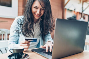 young woman paying with credit card on laptop computer