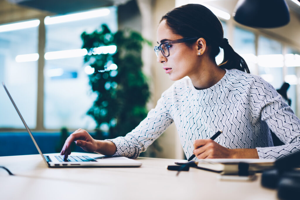 serious female secretary reading information making booking on a web page