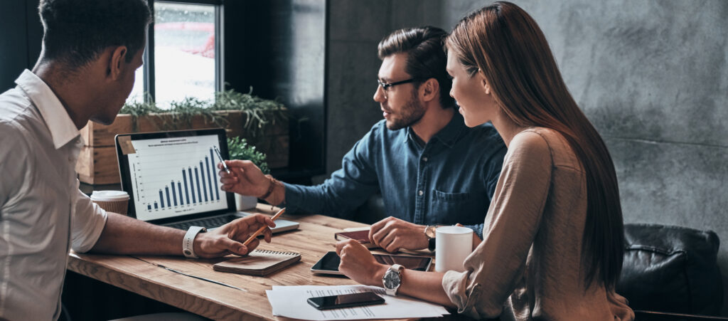 Group of young confident businesspeople analyzing data