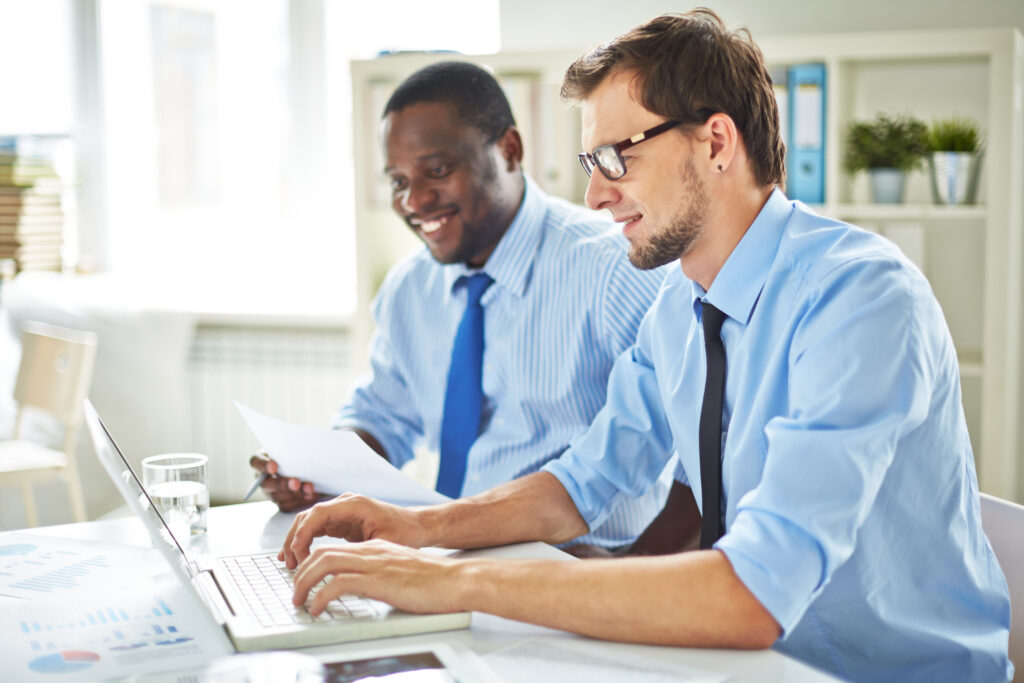 multiethnic group of enthusiastic managers gathered in boardroom working