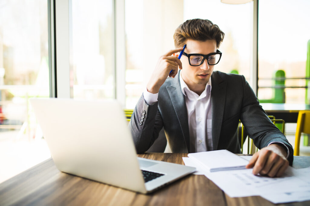 Happy man entering data from home on laptop