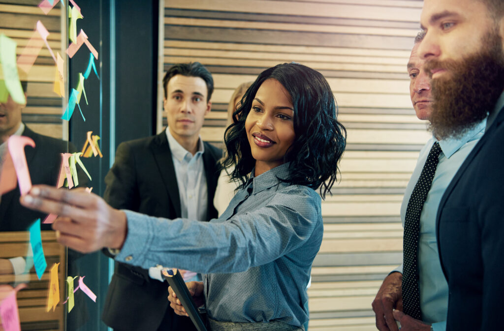 creative group of business people brainstorming putting sticky notes on a wall