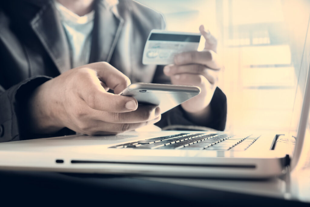 man's hands holding a credit card and phone